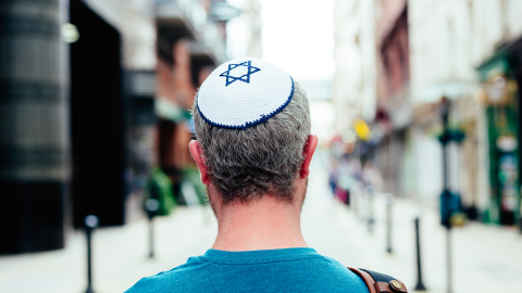Mid adult Jewish man in his 30s wearing a traditional Jewish skull cap (with star of David design)